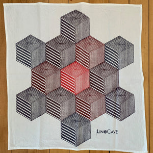 A hand block printed white flour sack towel in a red and purple in a geometric pattern.  