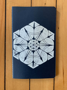 A medium navy Moleskine journal hand printed with a geometric pattern with white ink.