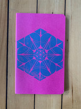 Load image into Gallery viewer, A medium pink Moleskine journal hand printed with a geometric pattern with blue ink.