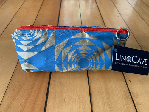 A warm beige and blue silk pencil case by LinoCave. Has a dark orange zipper.