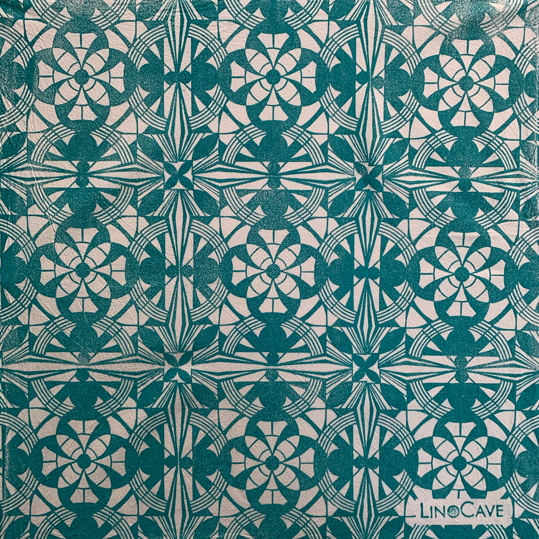 A hand block printed white flour sack towel in turquoise in a geometric pattern.  